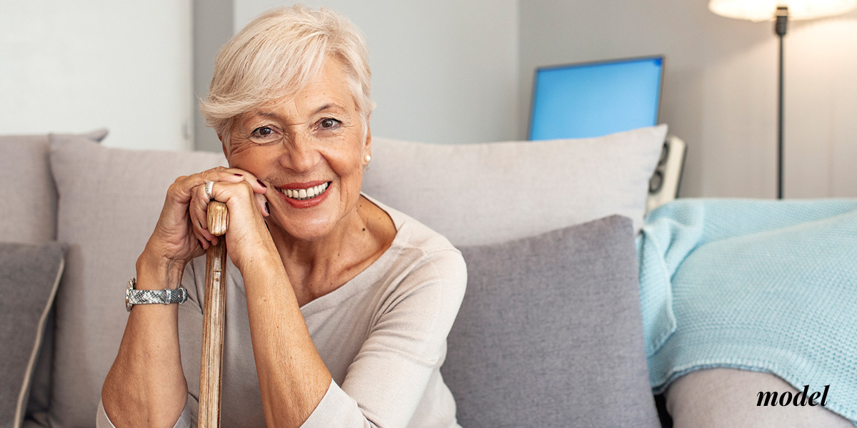Elderly model sitting on couch smiling | emmett plastic surgery