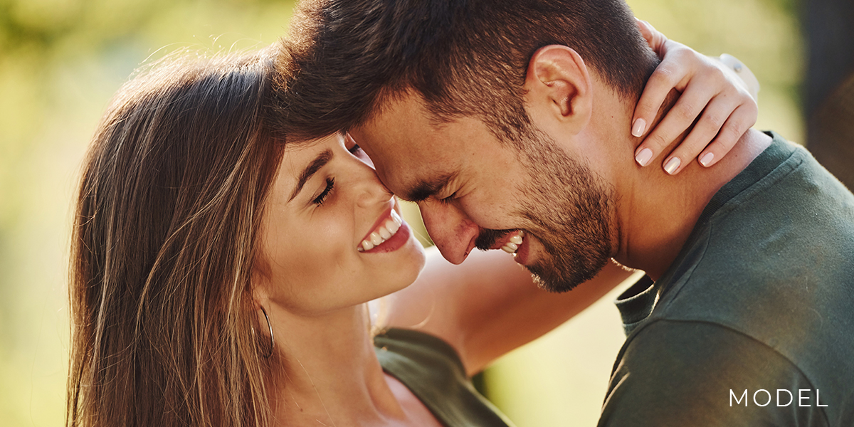 A pair of models portray a happy romantic couple | emmett plastic surgery