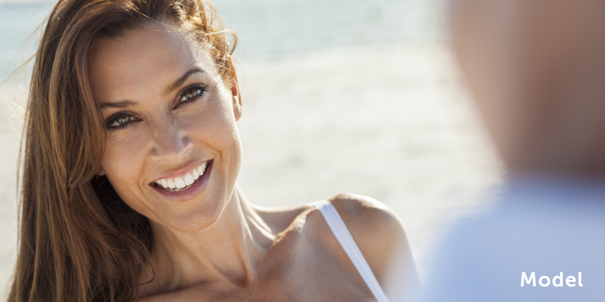 Smiling model at the beach | emmett plastic surgery